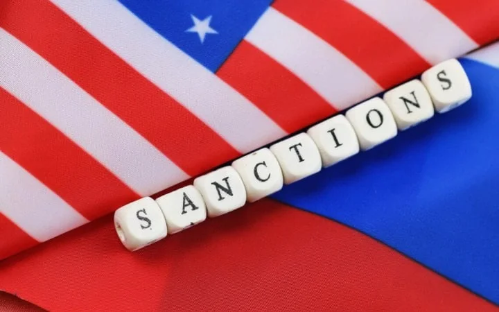 Прапори США та РФ з кубиками SANCTIONS щодо санкцій проти Росії