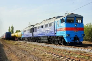Синій тепловоз Укрзалізниці тягне жовті цистерни рейками