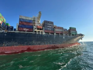 Велике контейнерне судно CMA CGM з вантажем пливе морем під чистим небом
